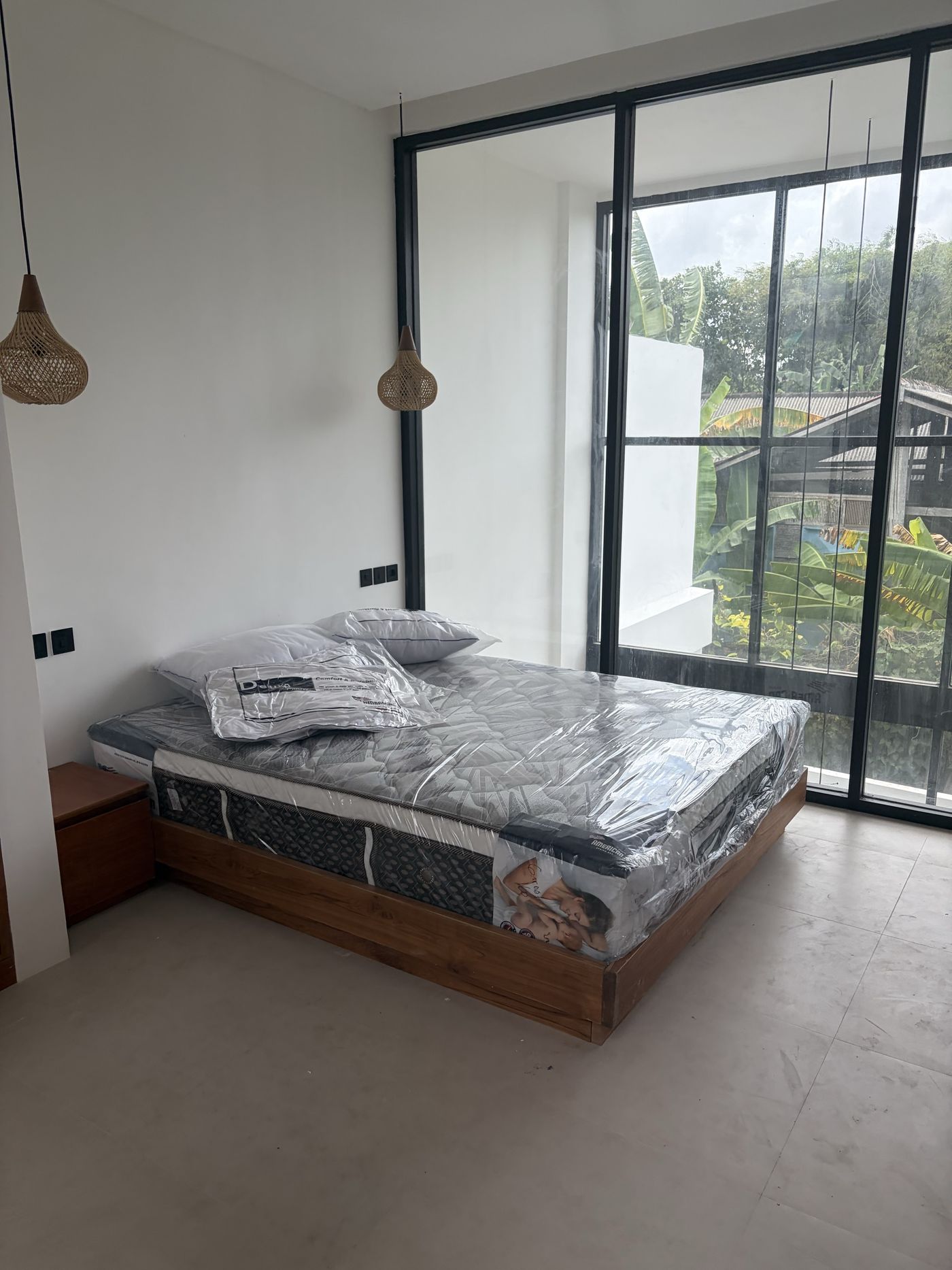 On site, Villa 1: bedroom with corner black-framed glazing onto the treeline