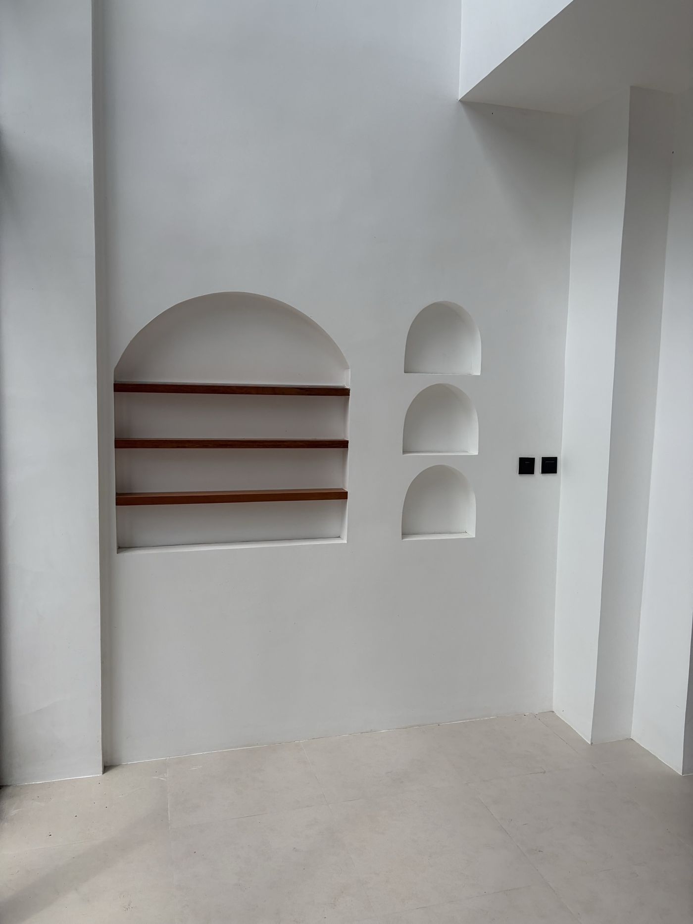 On site, Villa 1: hand-plastered wall with arched display niches and timber shelves