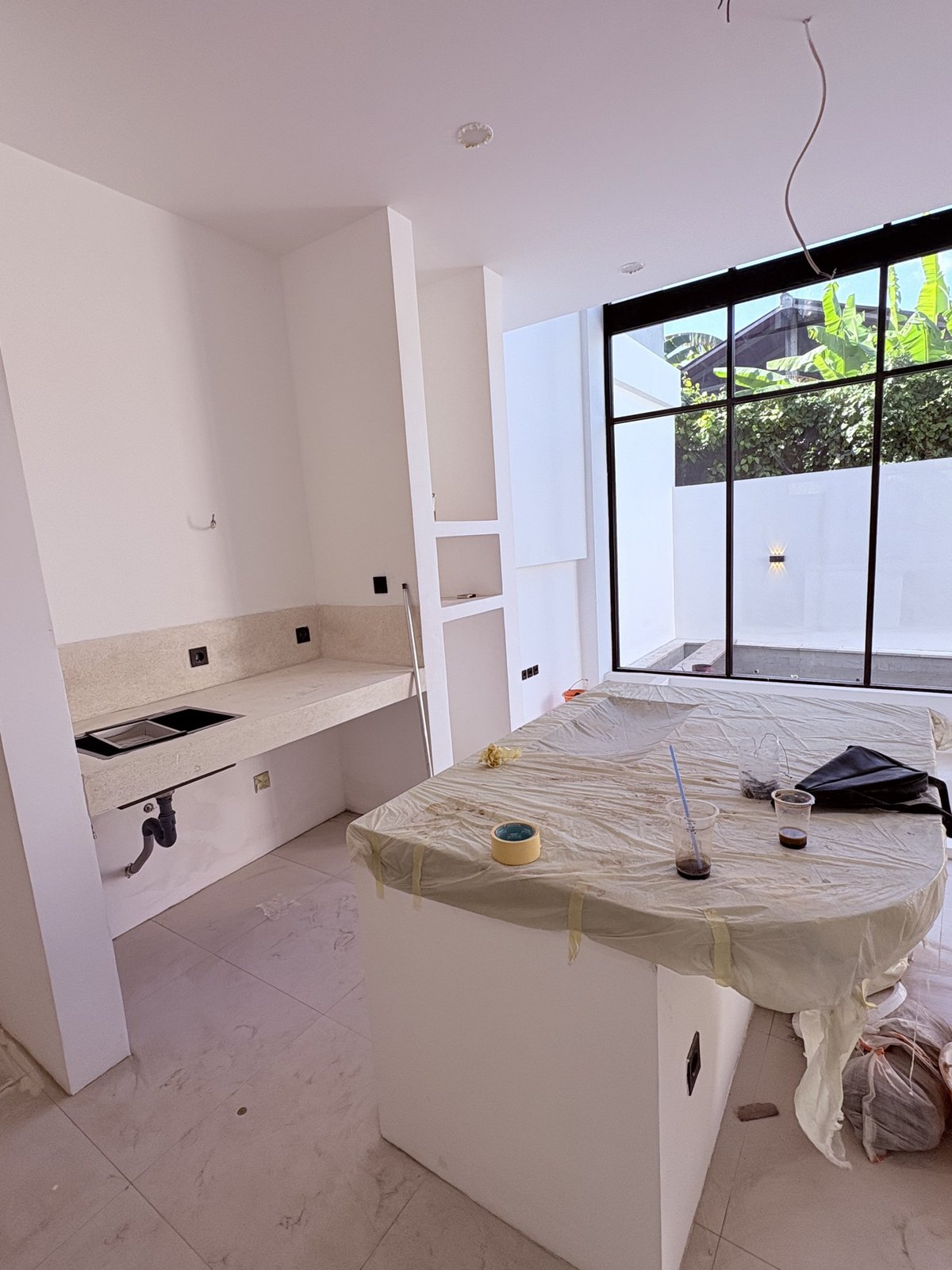On site: terrazzo island kitchen and built-in counter beside black-framed glazing onto the garden